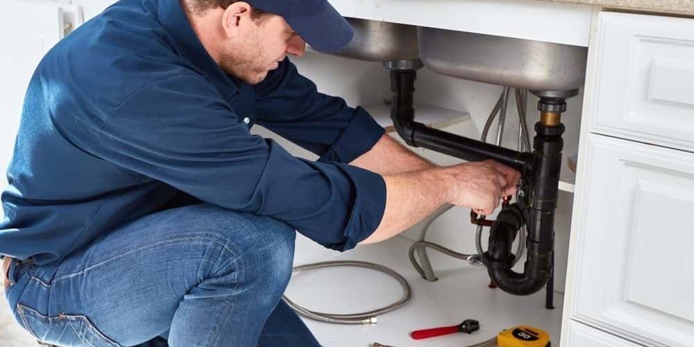 plumber repairing kitchen sink