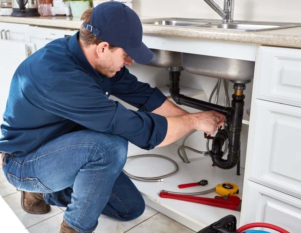 plumber repairing kitchen sink