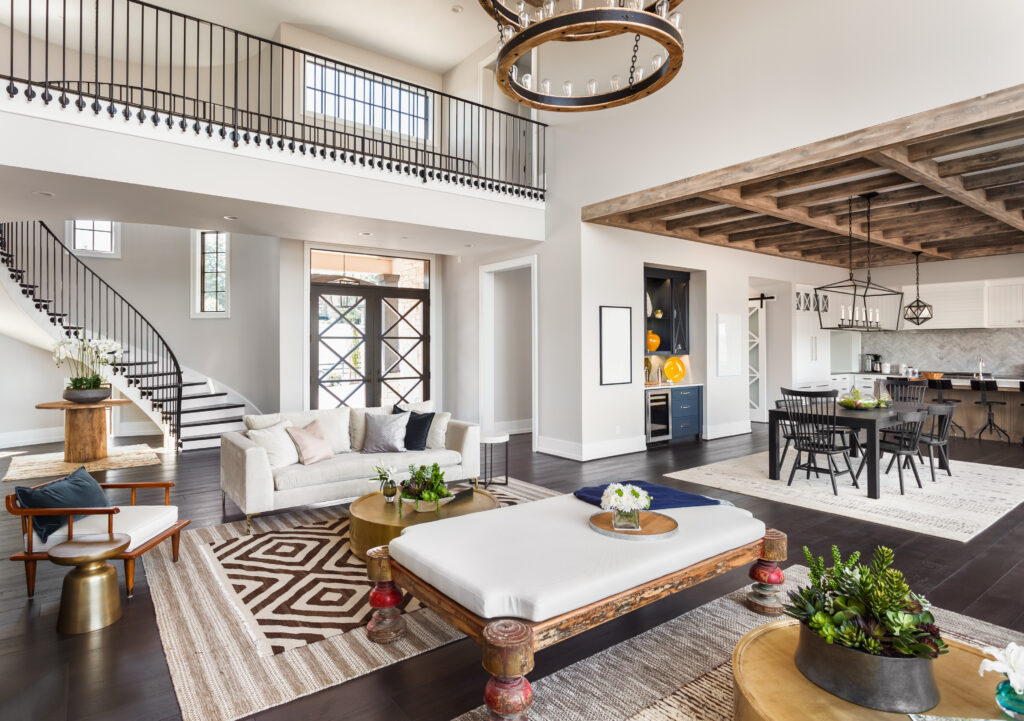 Stunning Panorama of Luxury Home Interior with Open Concept Floor Plan: Shows Living Room, Dining Room, Kitchen, and Entry. Elegant Stairs Lead up to Second Story. -