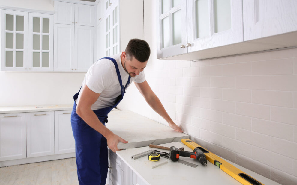 A remodeler installing new countertop in modern kitchen