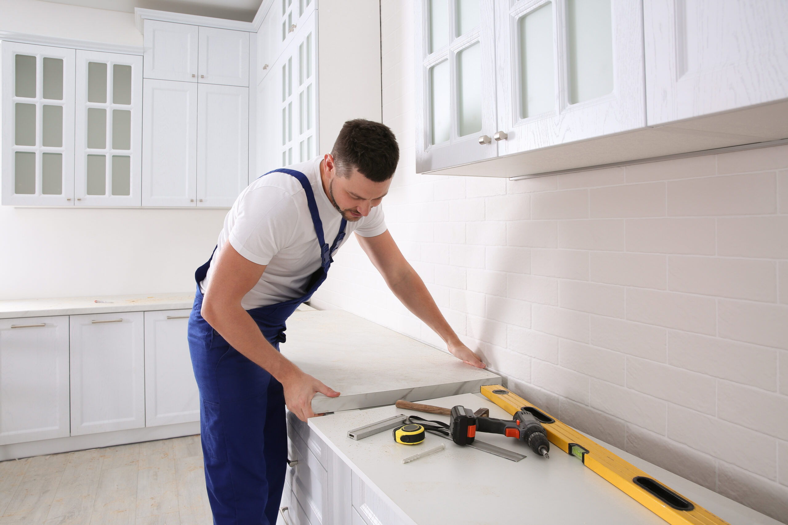 A remodeler installing new countertop in modern kitchen